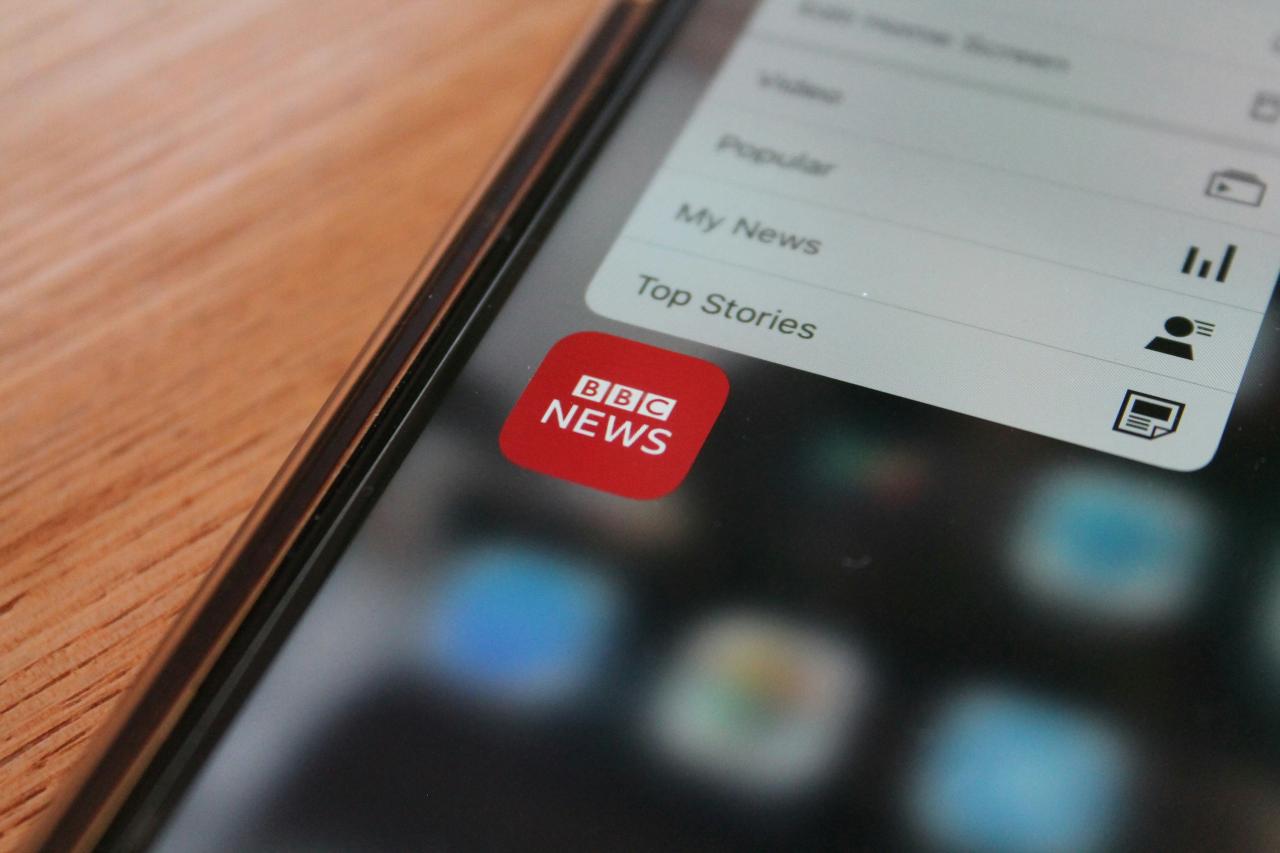 iPhone 5 hitam di atas meja kayu coklat